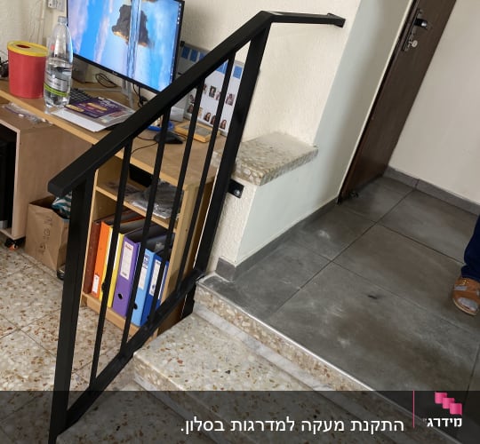 מעקה מתכת שחור על מדרגות שיש